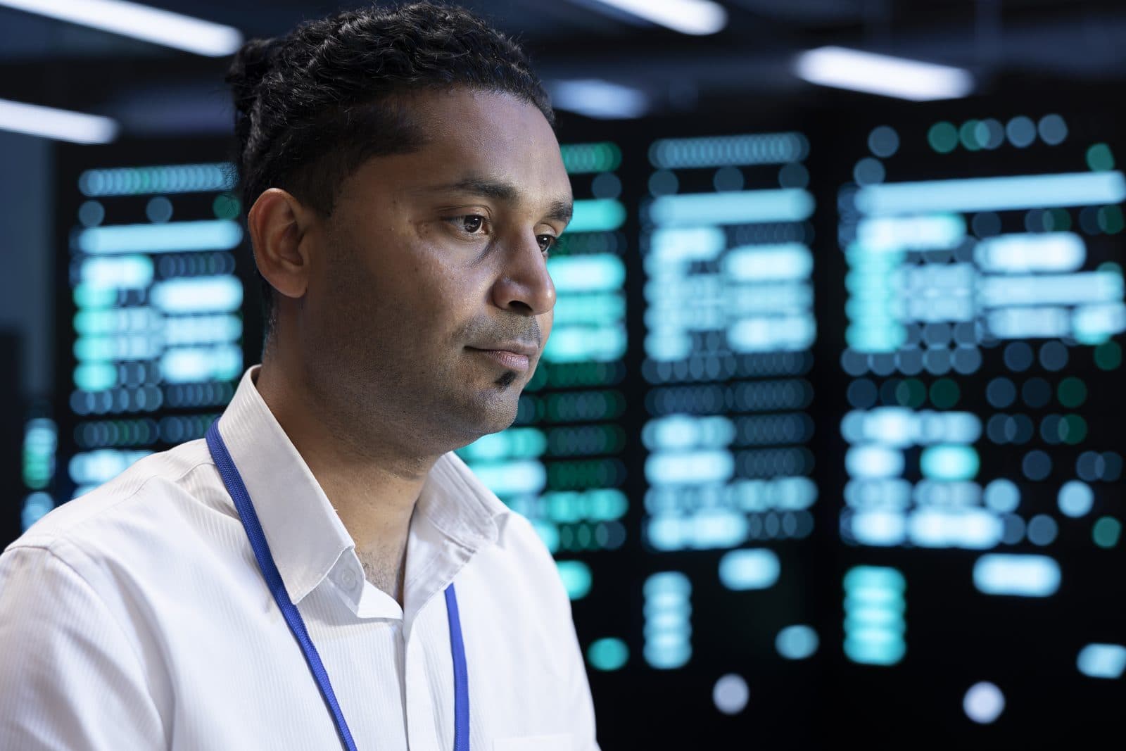 An engineer in front of lit server cabinets