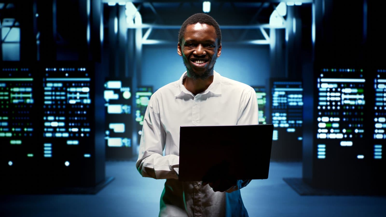 An engineer walking between server racks in a data centre