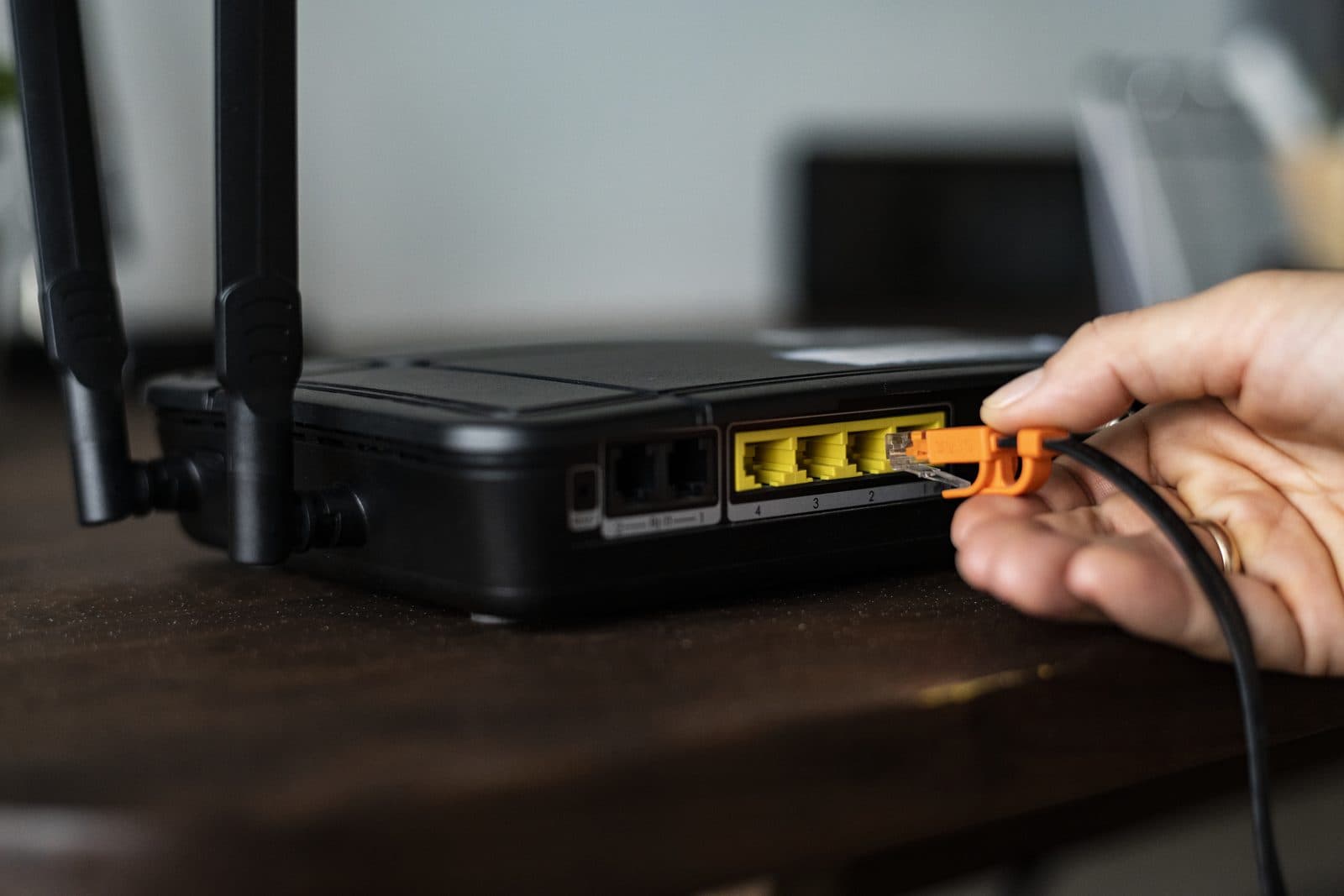 A network cable being plugged into a wireless router